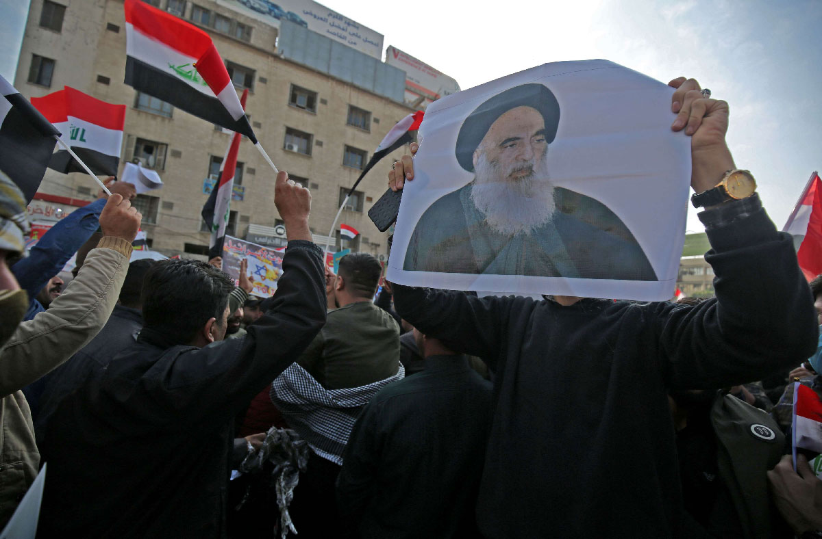 Protesters carry a picture of Shiite cleric Ali al-Sistani