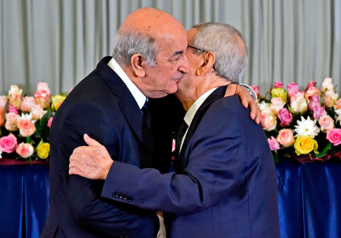 Algerian President-elect Abdelmadjid Tebboune (L) greets interim president Abdelkader Bensalah (R)