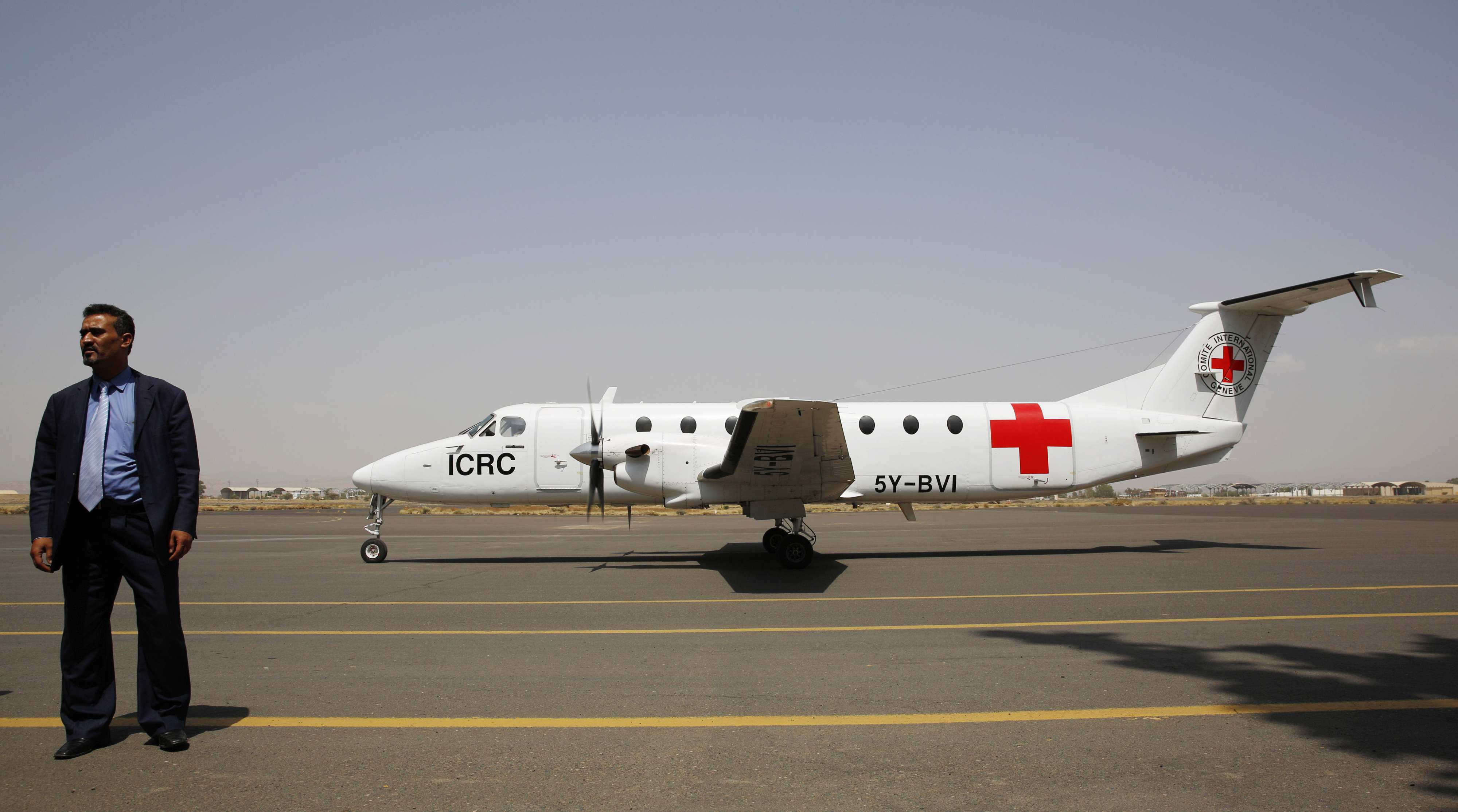 A Yemeni airport security official stands by a plane of the International Committee of the Red Cross