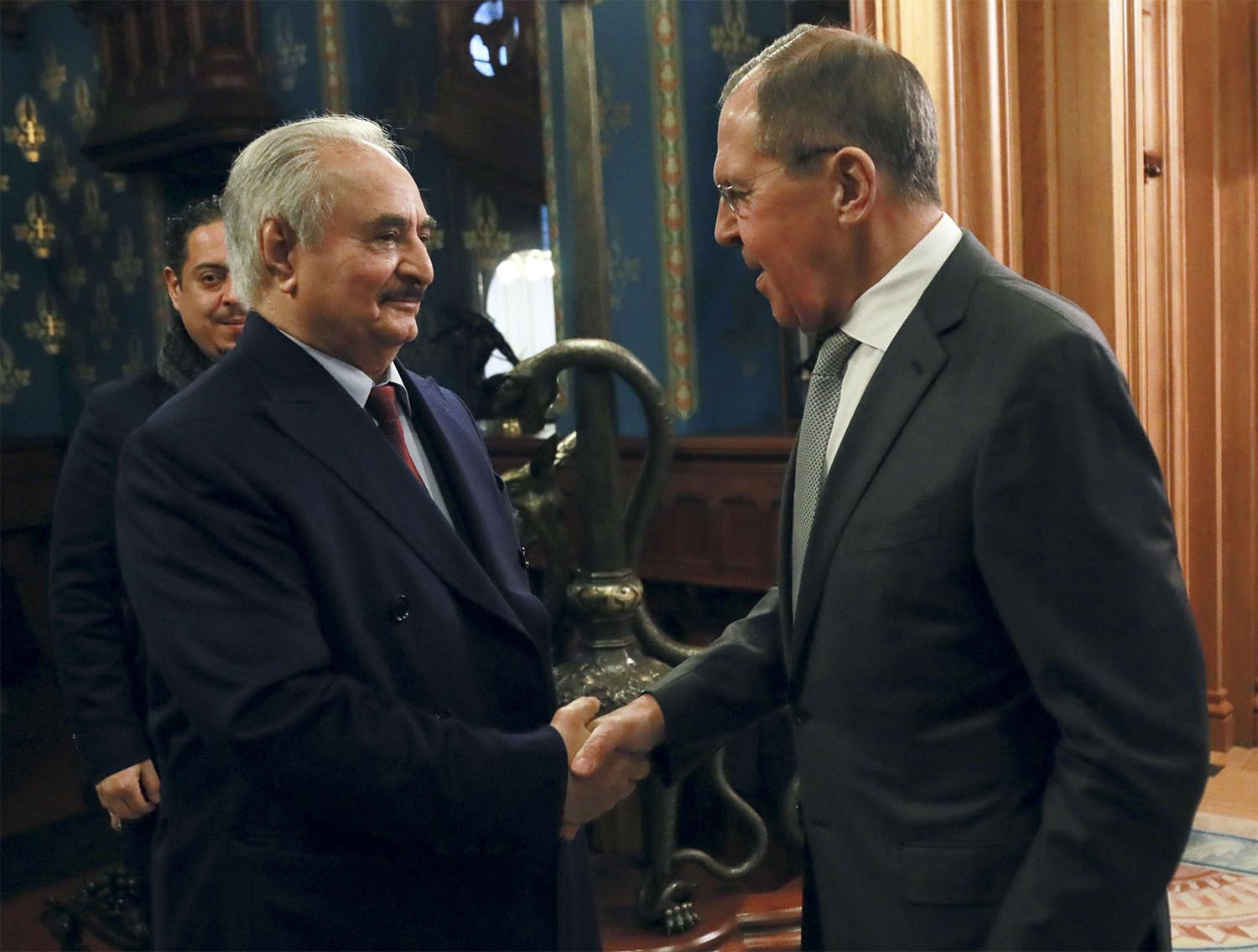 Russian Foreign Minister Sergey Lavrov, right, shakes hands with Khalifa Haftar