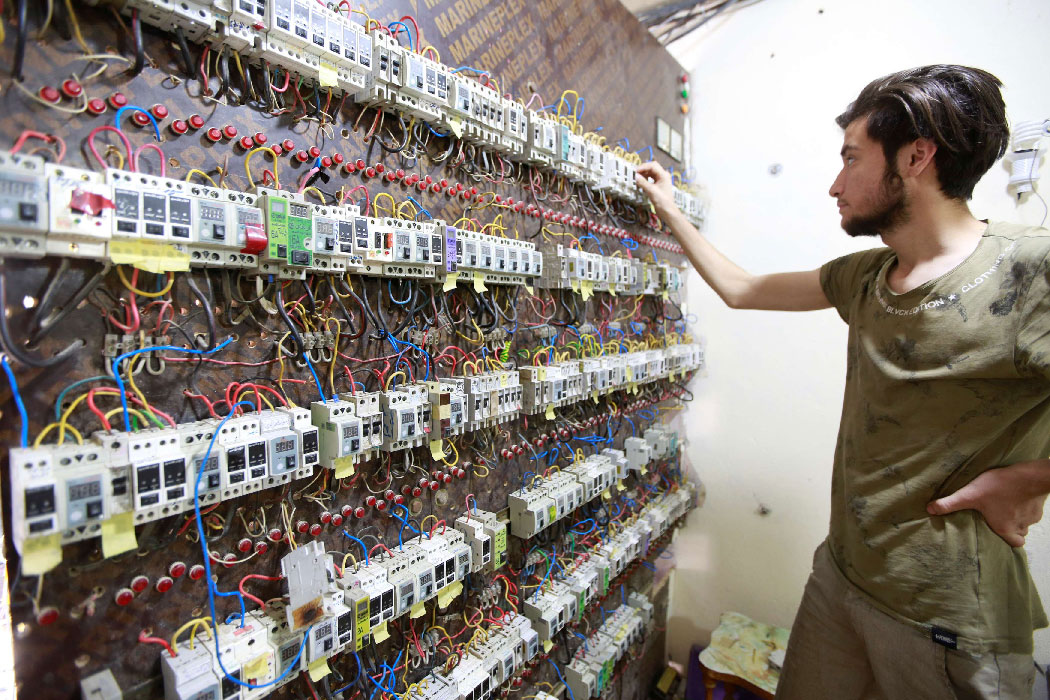 A worker is seen near an electrical generator board in Najaf, Iraq