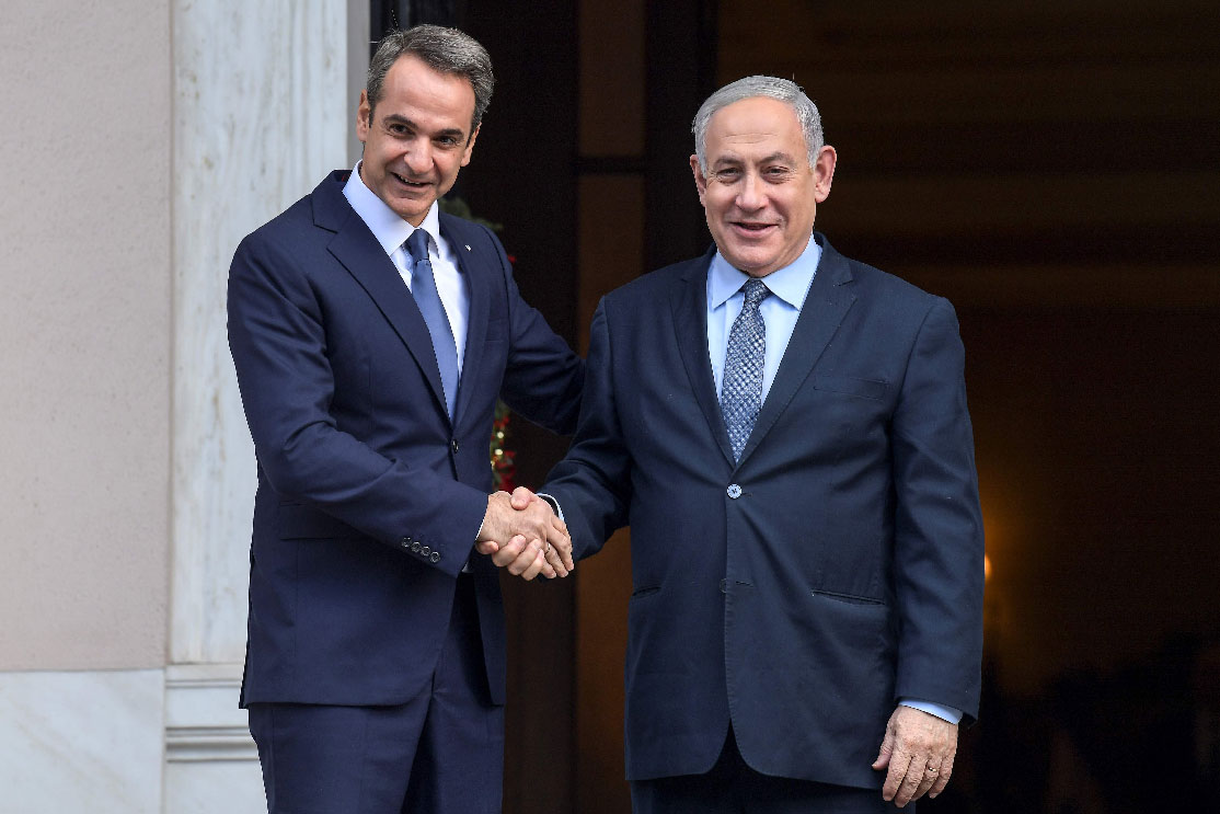 Greek Prime Minister Kyriakos Mitsotakis (L) shakes hands with his Israeli counterpart Benjamin Netanyahu