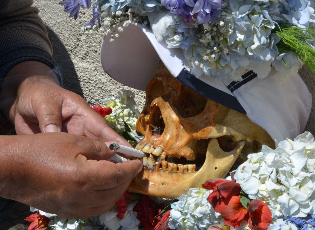 امرأة تضع سيجارة بين أسنان جمجمة بشرية أثناء الاحتفال بطقوس يوم الجماجم في كولومبيا
