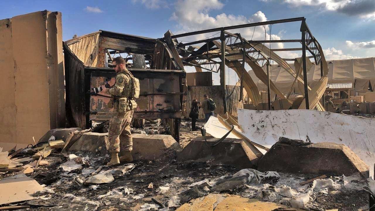 US soldiers and journalists inspect the rubble at a site of Iranian bombing, in Ain al-Asad air base, Anbar