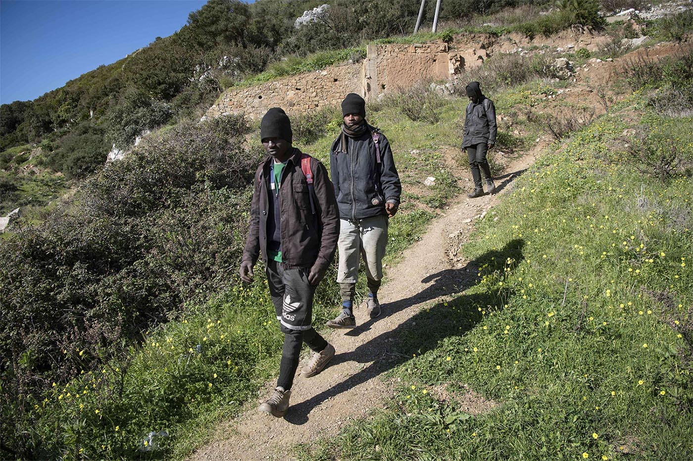 Guinean migrants walk near their hideout in the Belyounech forest, a few kilometres from Ceuta 