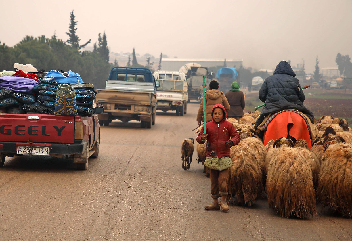 Syrians fleeing with their belongings on their way northwards toward the Turkish border
