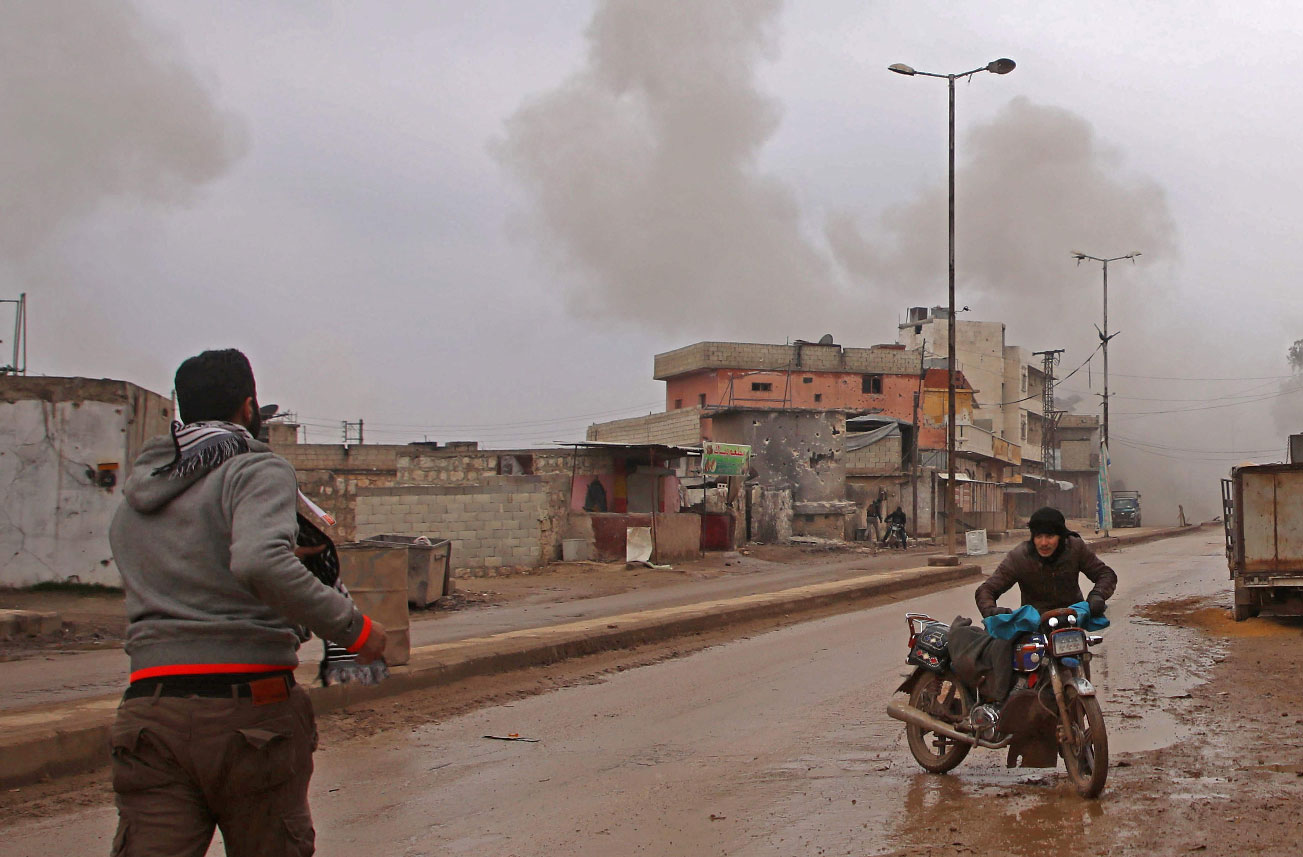 Syrian men flee the town of Atareb in the rebel-held western countryside of Syria's Aleppo province