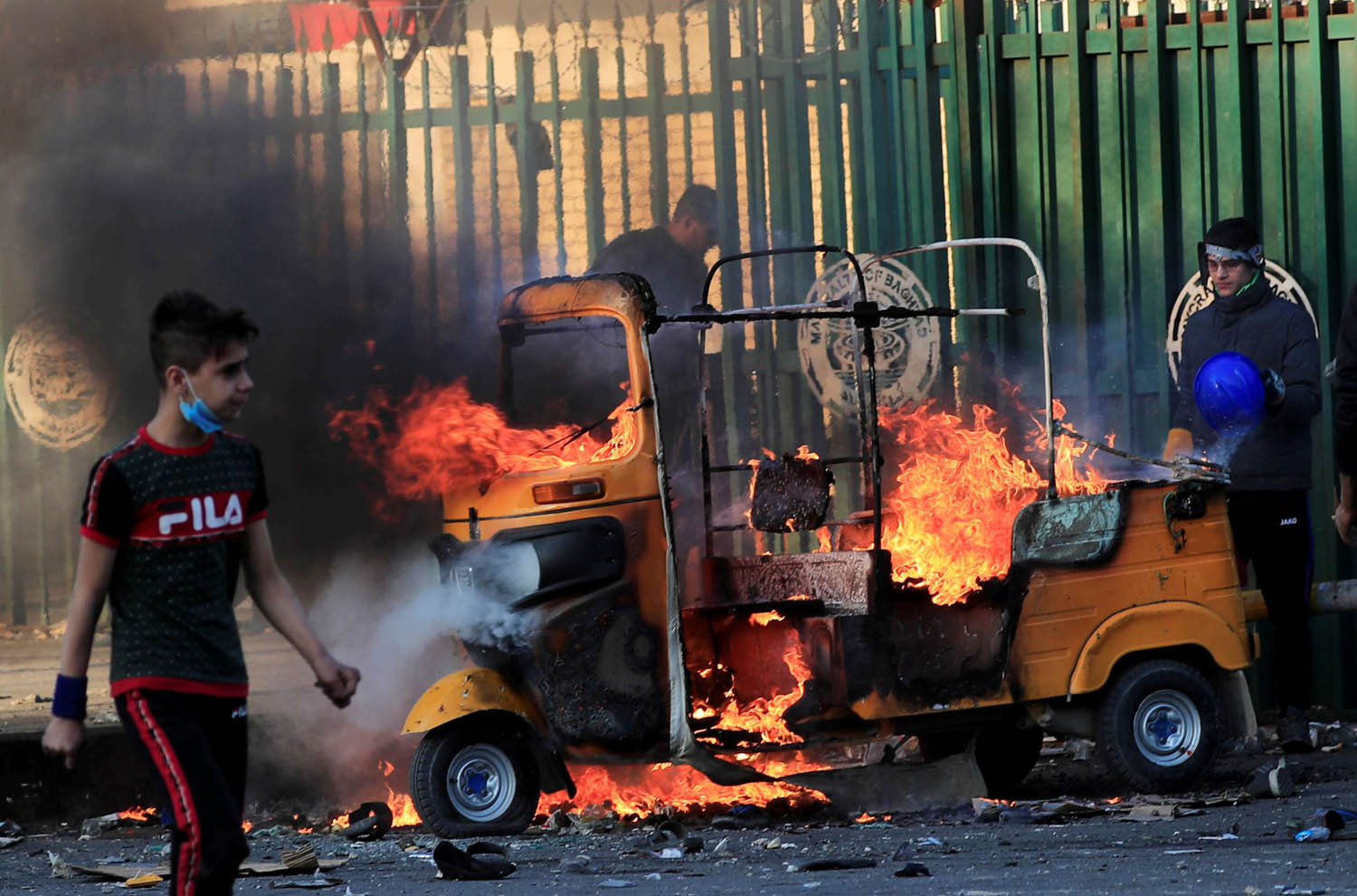 توك توك تحترق وسط بغداد بعد ان اضرمت قوات الأمن النار فيها