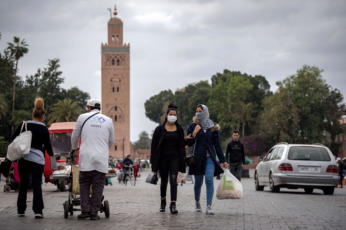 أشخاص يرتدون كمامات واقية يسيرون في ساحة جامع الفنا في مراكش
