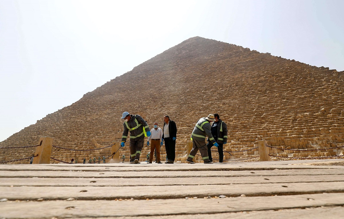 عمال البلدية المصريون يعقمون مقبرة أهرامات الجيزة 
