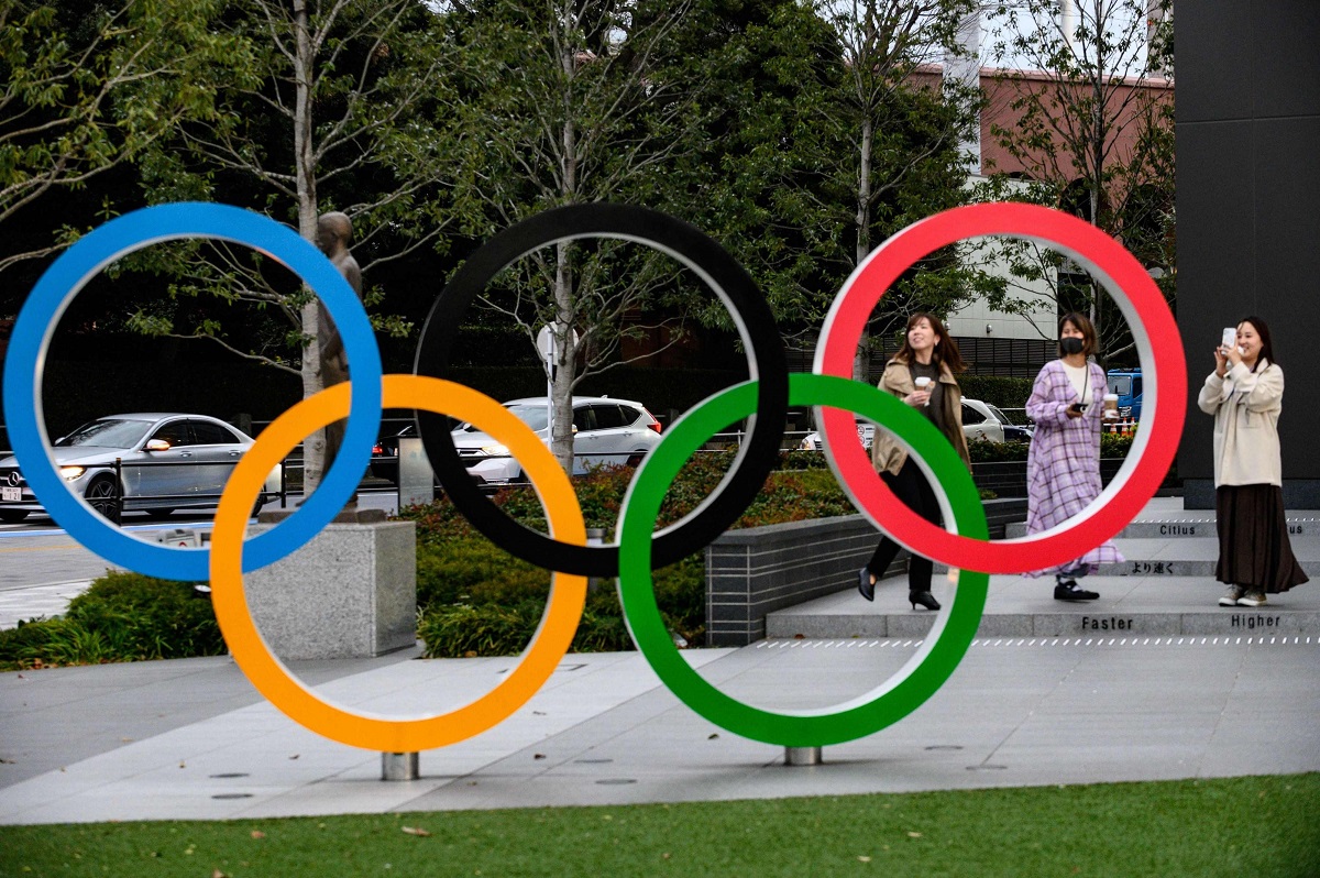 أشخاص يلتقطون صورا للحلقات الأولمبية خارج المتحف الياباني الأولمبي المغلق في طوكيو