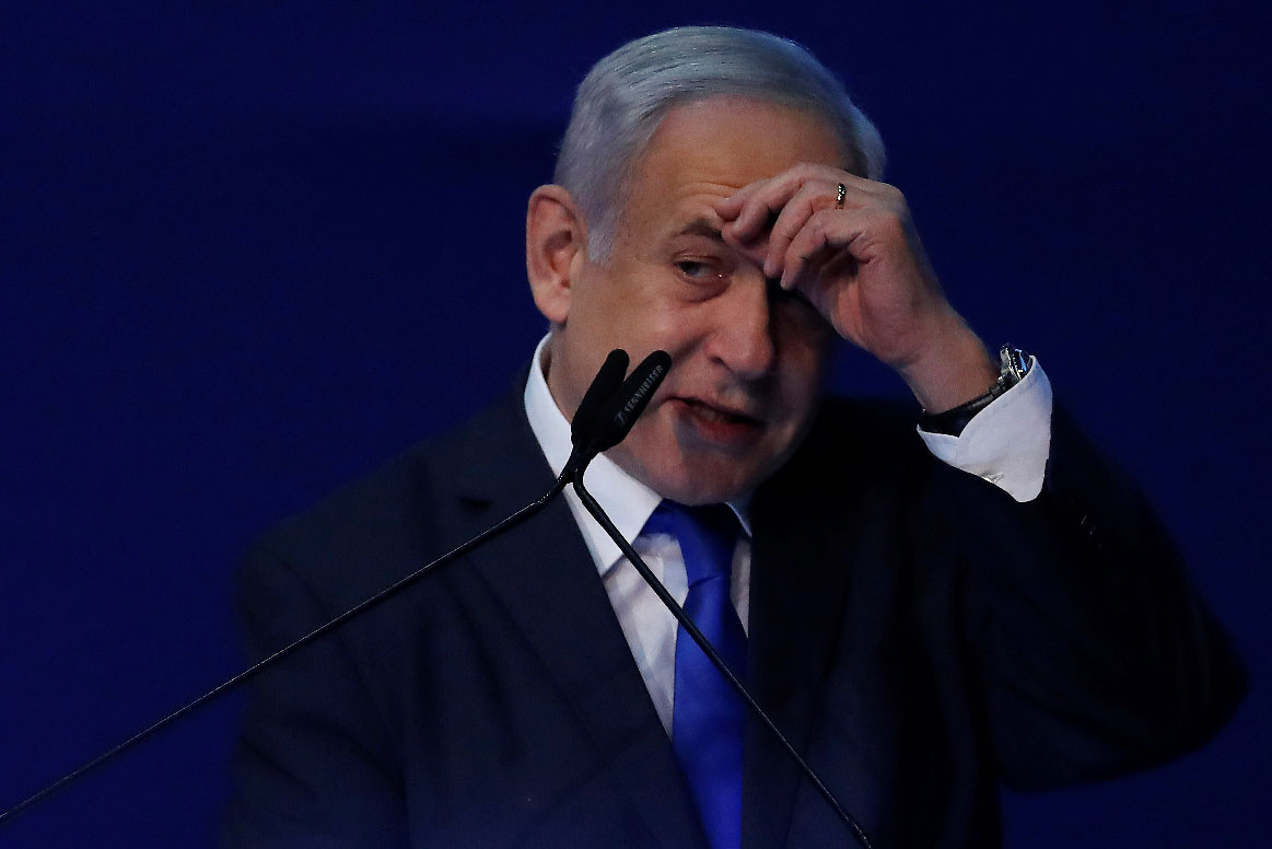 Israeli Prime Minister Benjamin Netanyahu gestures as he speaks to supporters following the announcement of exit polls in Israel's election at his Likud party headquarters in Tel Aviv