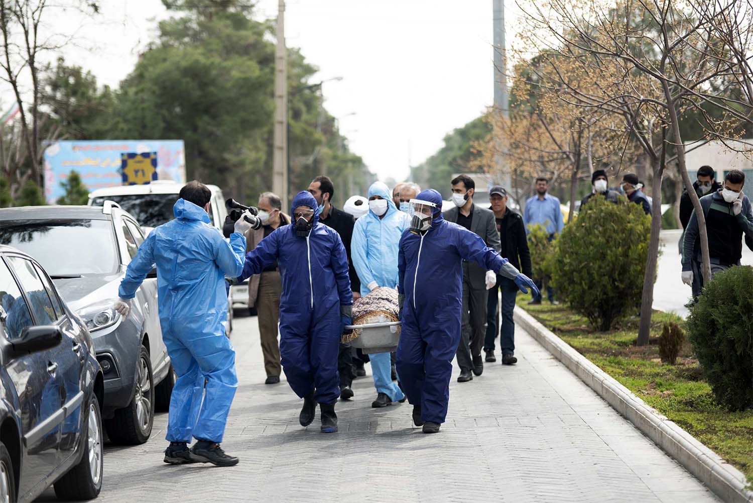 Men wearing protective gear carry the body of Fatemeh Rahbar, a lawmaker-elect from Tehran constituency, who died on Saturday after being infected with the new coronavirus