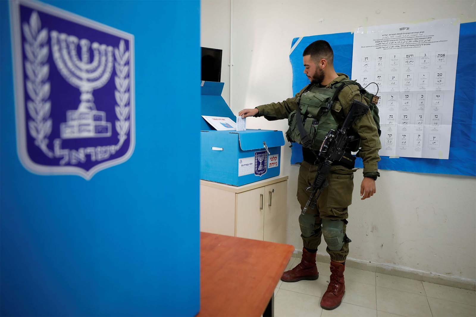 Israeli soldier casts his ballot as he votes in Israel's national election in a mobile polling station at a military post near Kibbutz Zikim