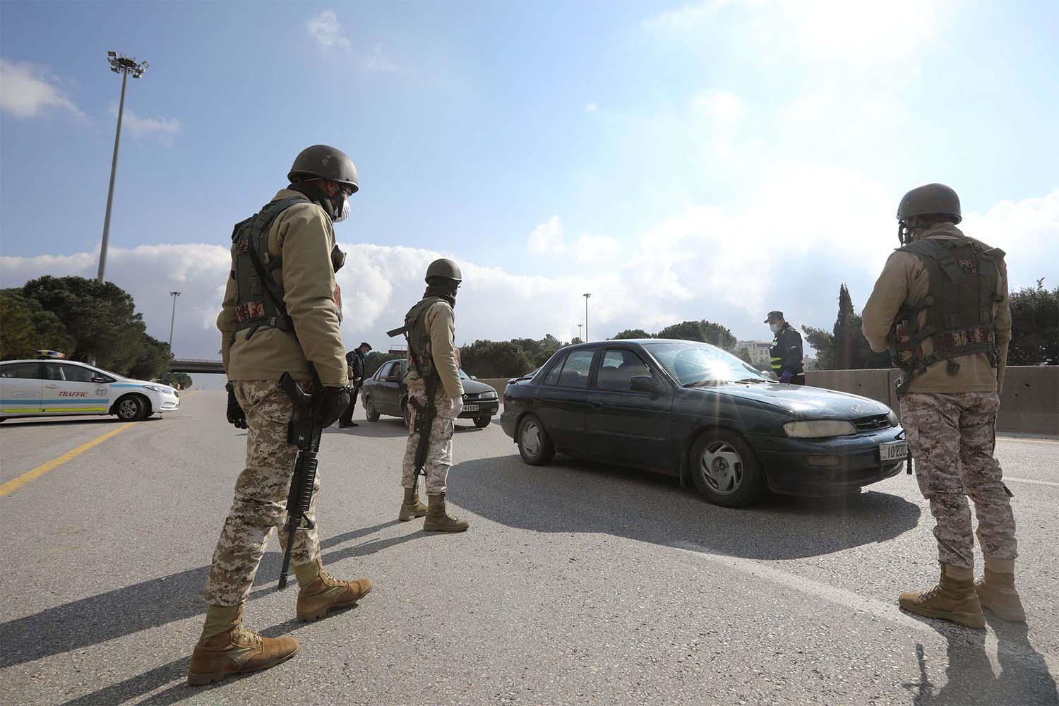 Jordanian army members and police personnel guard at a checkpoint during the second day of a nationwide curfew