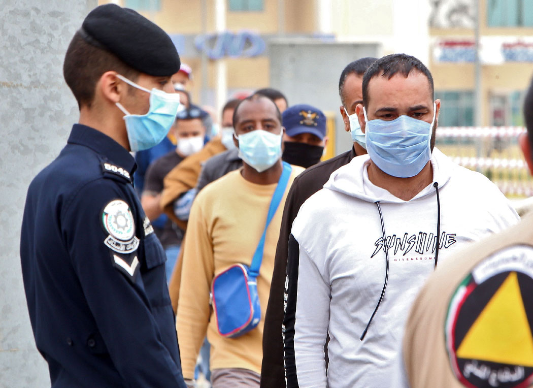 Expatriate workers arrive at a Kuwaiti health ministry containment and screening zone for COVID-19