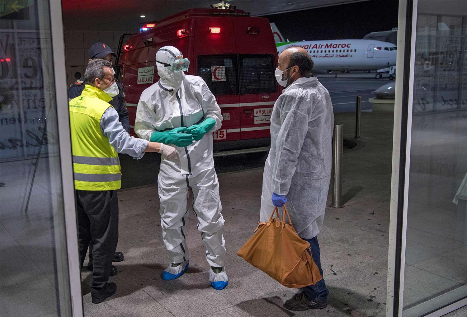 Moroccan health workers scan passengers arriving from Italy for coronavirus COVID-19 at Casablanca Mohammed V International Airport 