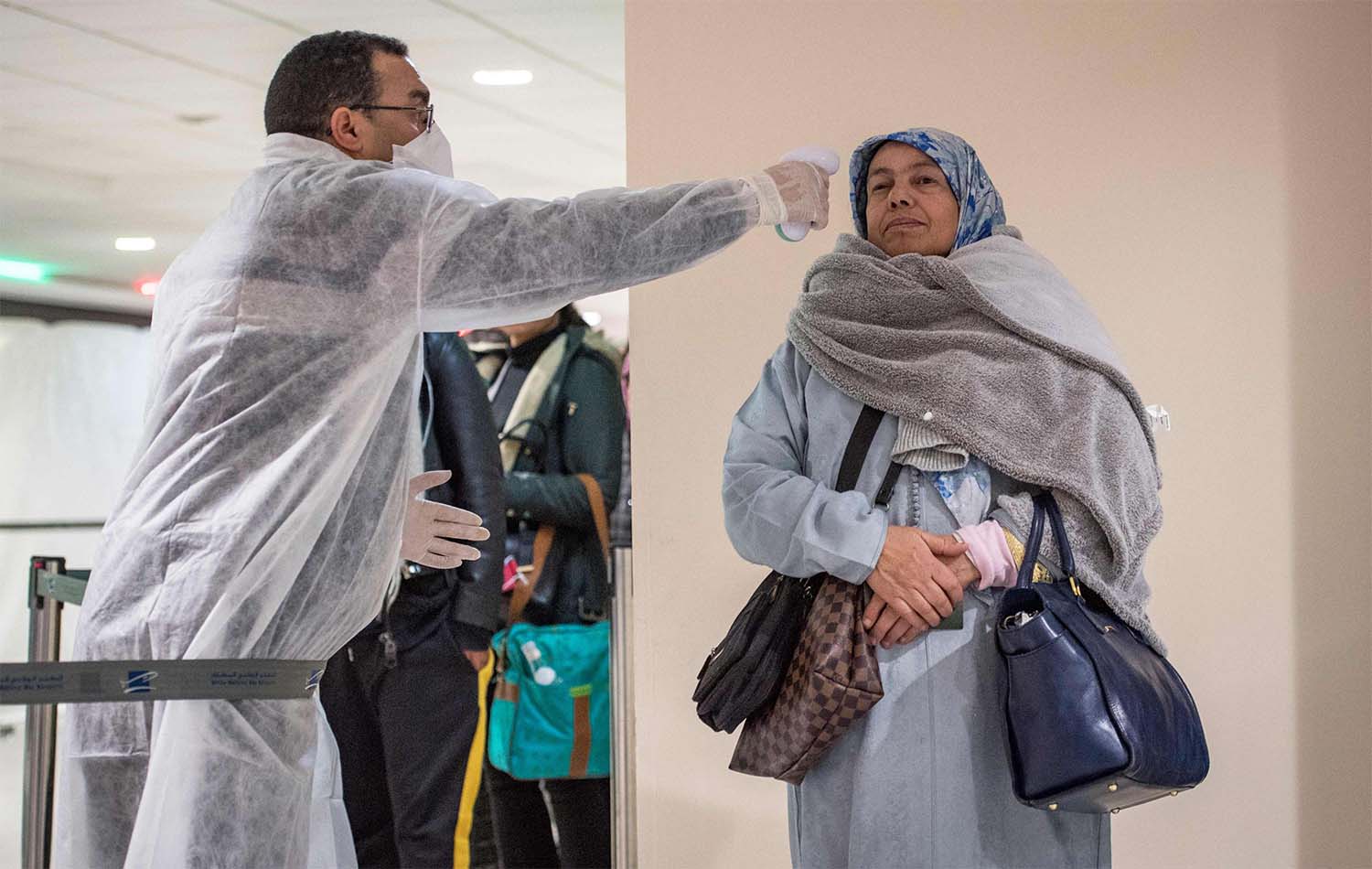 Moroccan health workers scan passengers arriving from Italy for coronavirus COVID-19 at Casablanca Mohammed V International Airport on March 3