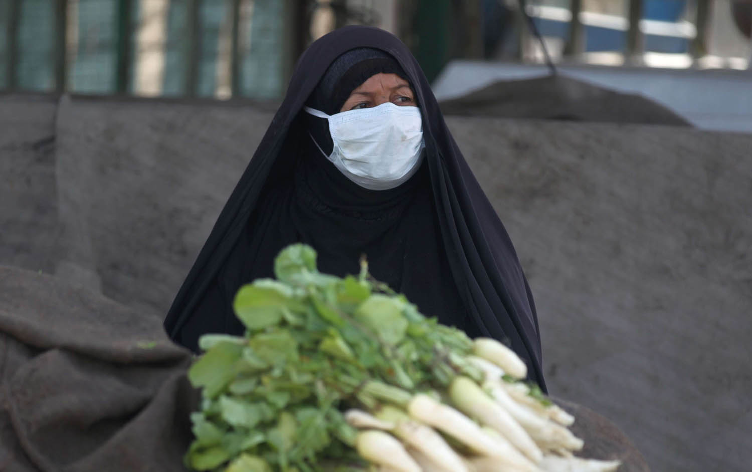 بائعة عراقية ترتدي كمامة للوقاية من كورونا في مدينة الصدر ببغداد