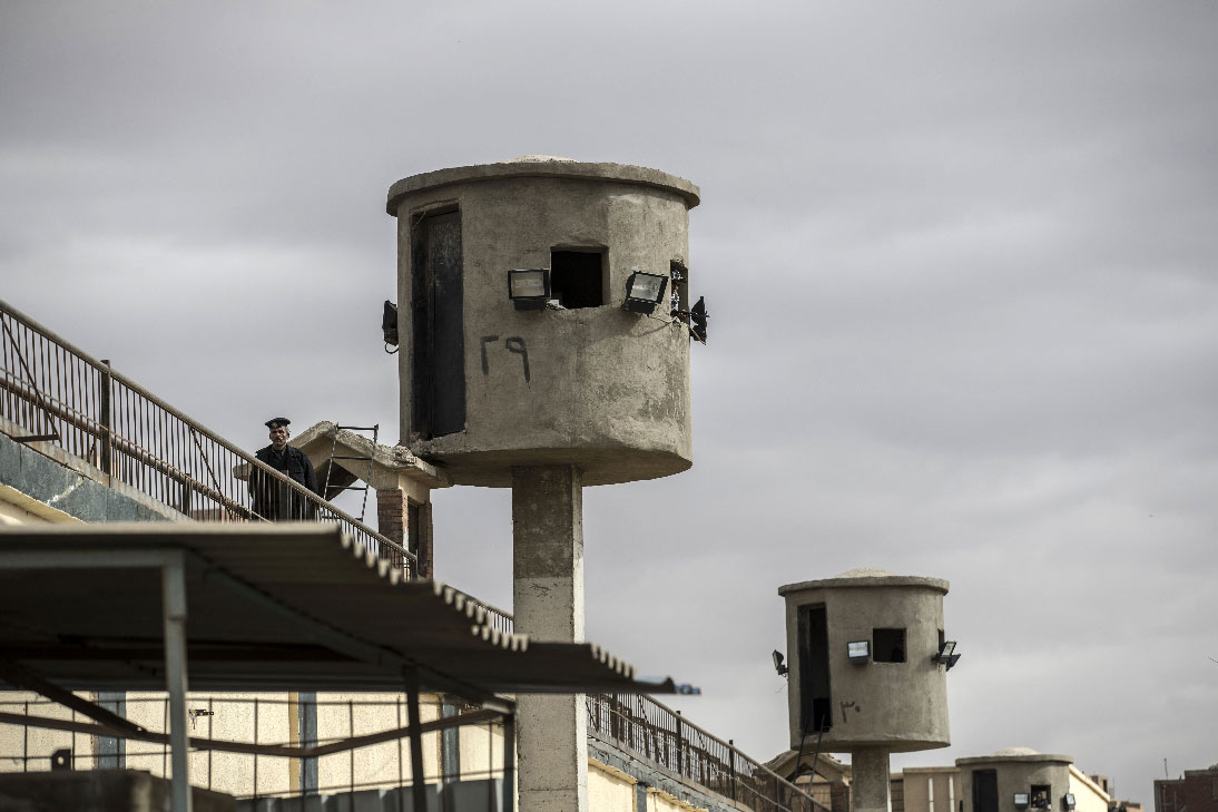 An Egyptian policeman stands near watch towers at Tora prison in Cairo