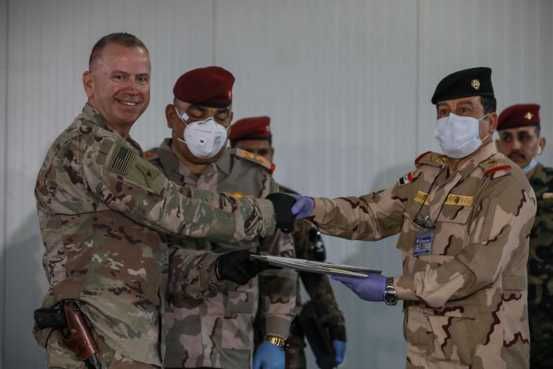 US Brigadier General Vincent B. Barker (L) shakes hands with Iraq's Staff Major General Mohammad Fadhel Abbas during the handover ceremony of the K1 air base