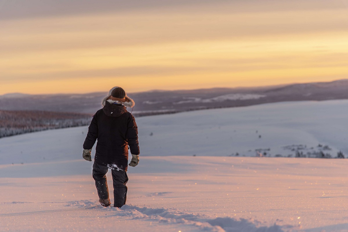 راع لحيوان الرنة يسير عبر الثلج في منطقة القطب الشمالي بالسويد