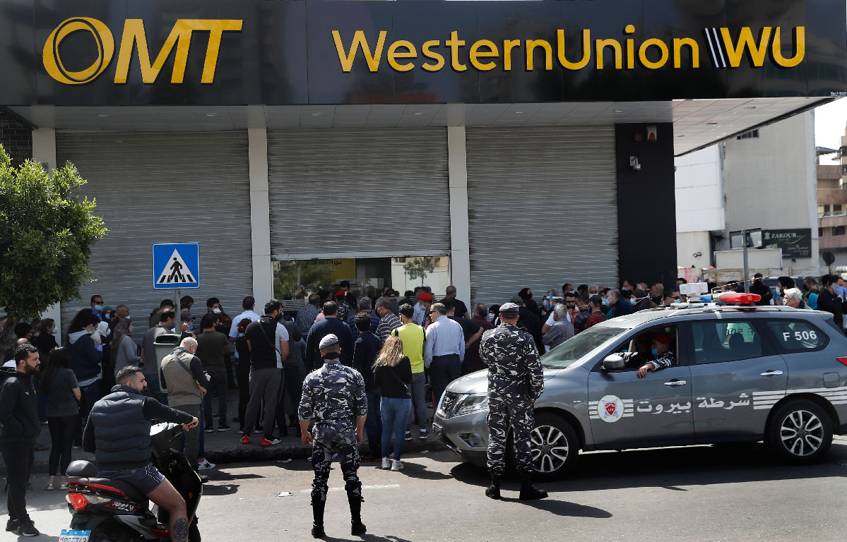 Lebanese citizens queue outside a Western Union shop to receive their money transfer in U.S. dollar currency