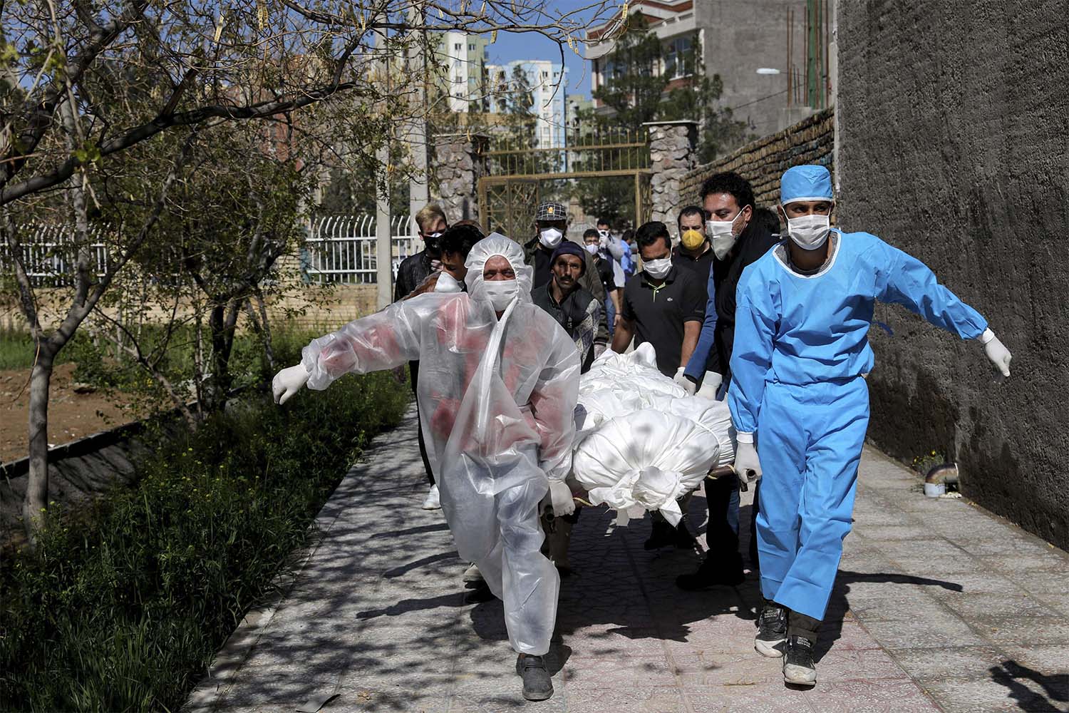 People carry the body of a victim who died after being infected with the new coronavirus at a cemetery just outside Tehran