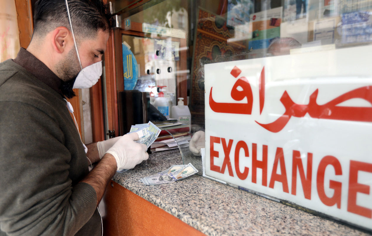 A customer is served at the counter of a currency exchange store in Beirut