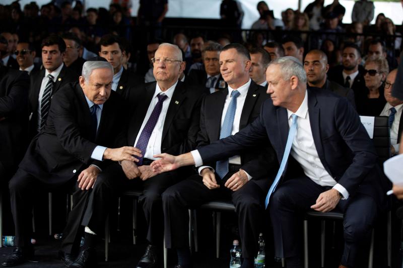 Head of Israel’s Blue and White Party Benny Gantz (R) and Israeli Prime Minister Binyamin Netanyahu shake hands