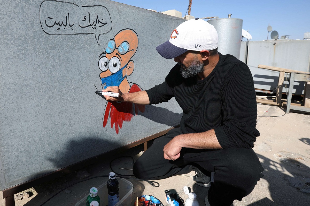 رسام الكاريكاتير الأردني أسامة حجاج يرسم على خزانات المياه 