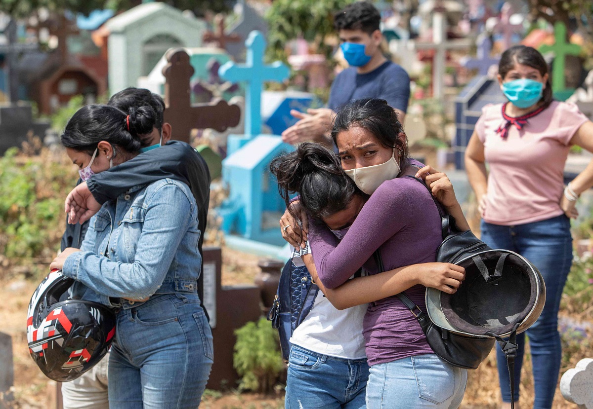 أقارب أحد المتوفين بفيروس كورونا يبكون بعد دفنه بمقبرة في ماناغوا عاصمة نيكاراغوا