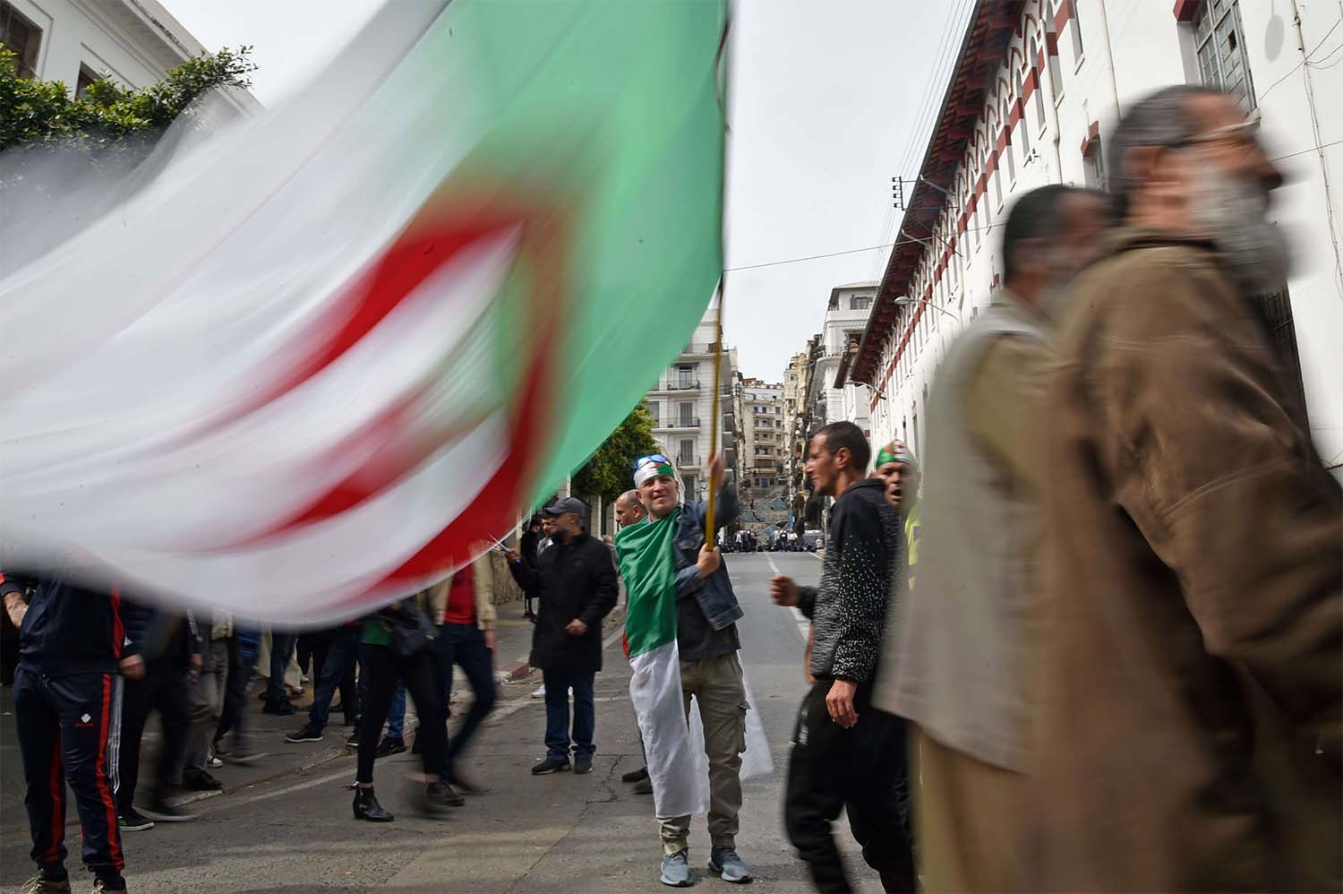 An Algerian protester waves the national flag during a weekly anti-government demonstration in Algiers on March 13