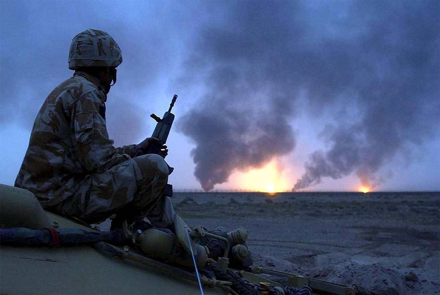 British soldier watching burning oil wells in southern Iraq on March 20, 2003 during US-led invasion of Iraq 