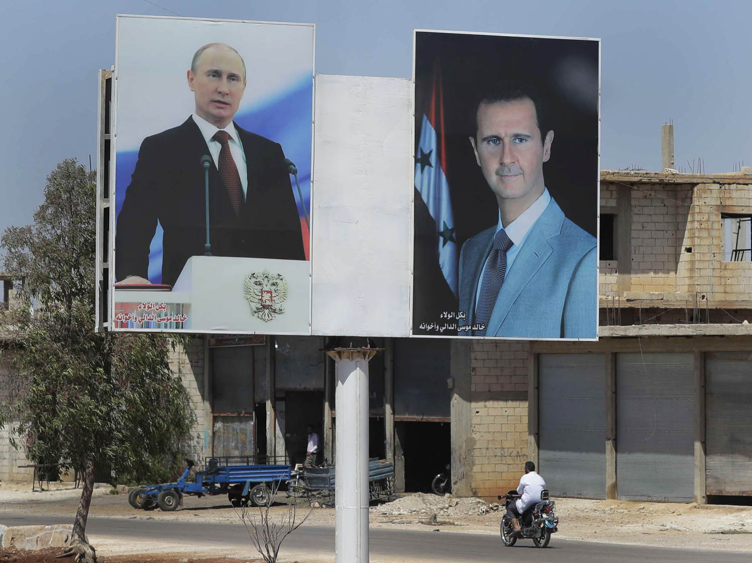 صورتان للرئيسين السوري بشار الأسد والروسي فلاديمير بوتين في بلدة الرستان
