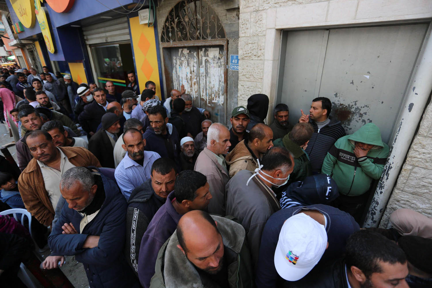 فلسطينيون ينتظرون صرف رواتبهم في مخيم خان يونس في غزة
