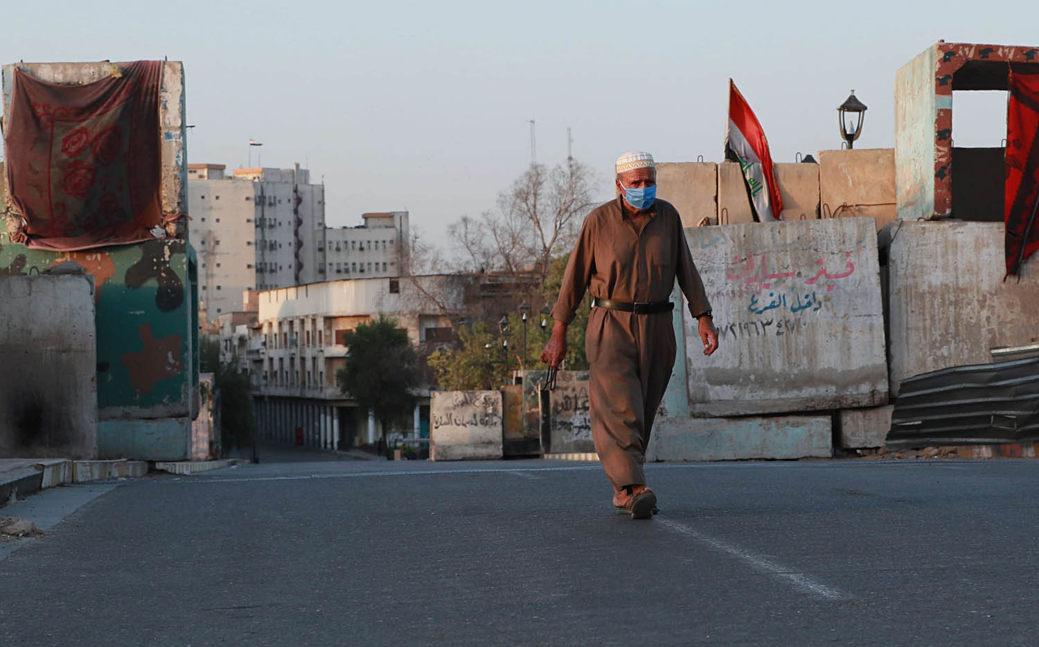 عراقي يمشي وسط شوارع بغداد المقفرة