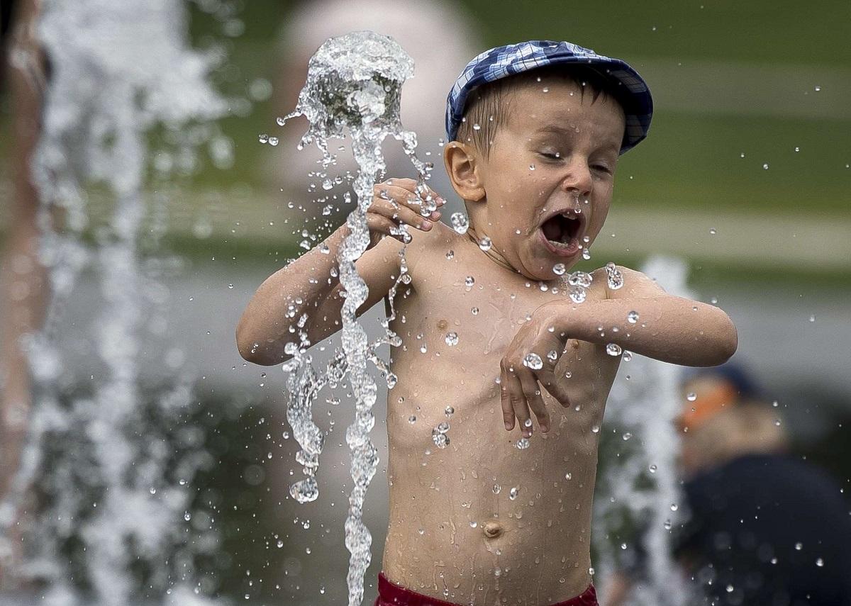 طفل يلعب في الماء خلال نهار صيفي حار