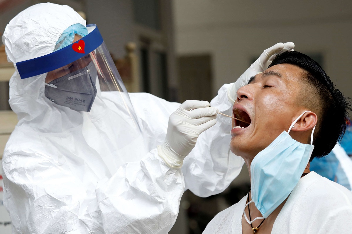 ممرض فيتنامي يأخذ مسحة من أحد الاشخاص لاختبار فيروس كورونا