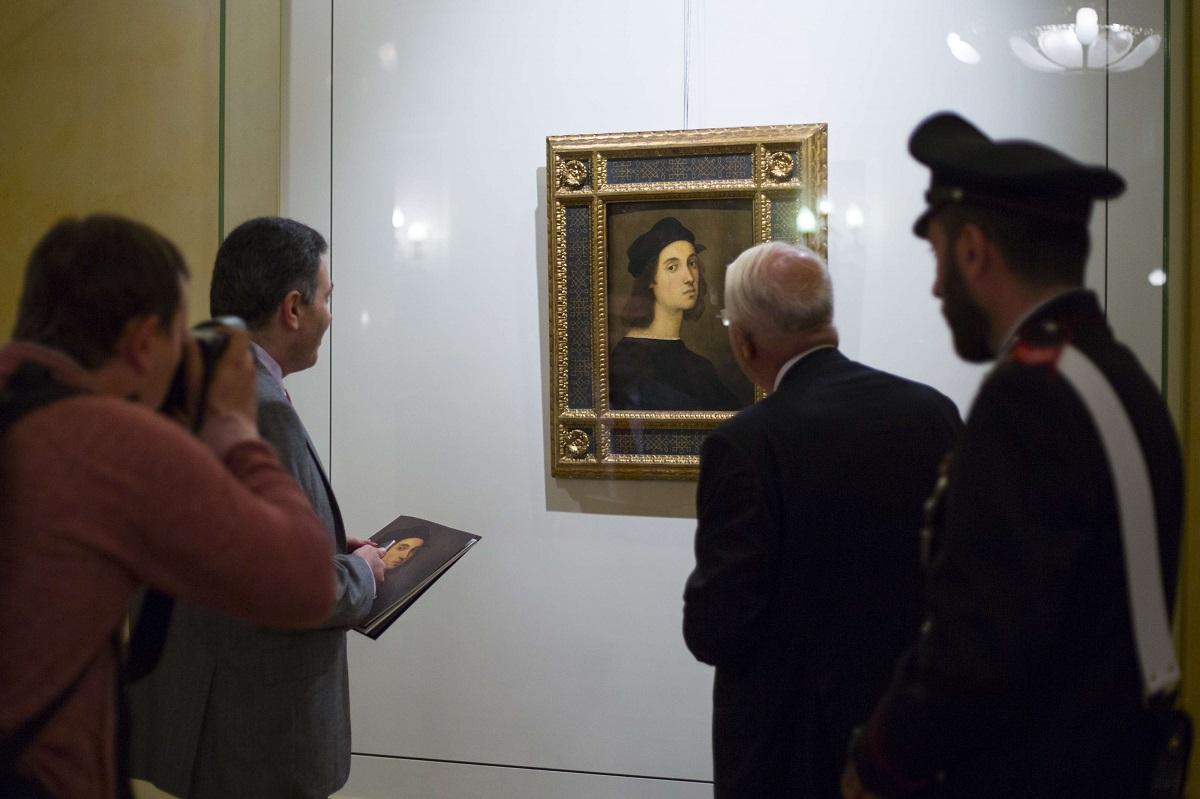 زوار ينظرون إلى صورة ذاتية للرسام رفائيل في معرض بالسفارة الايطالية بموسكو