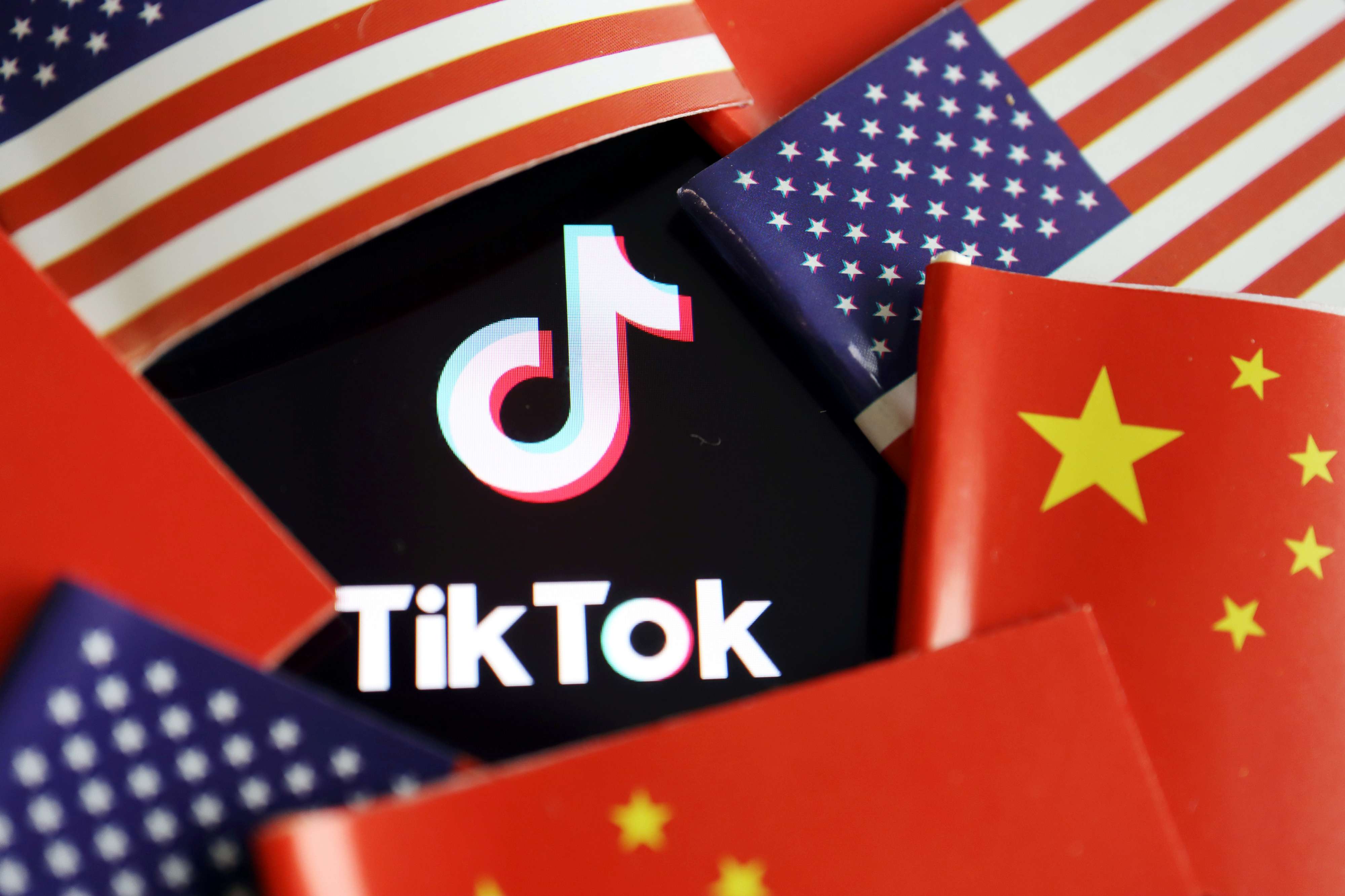 شعار تطبيق تيك توك يظهر وسط علمي الولايات المتحدة والصين