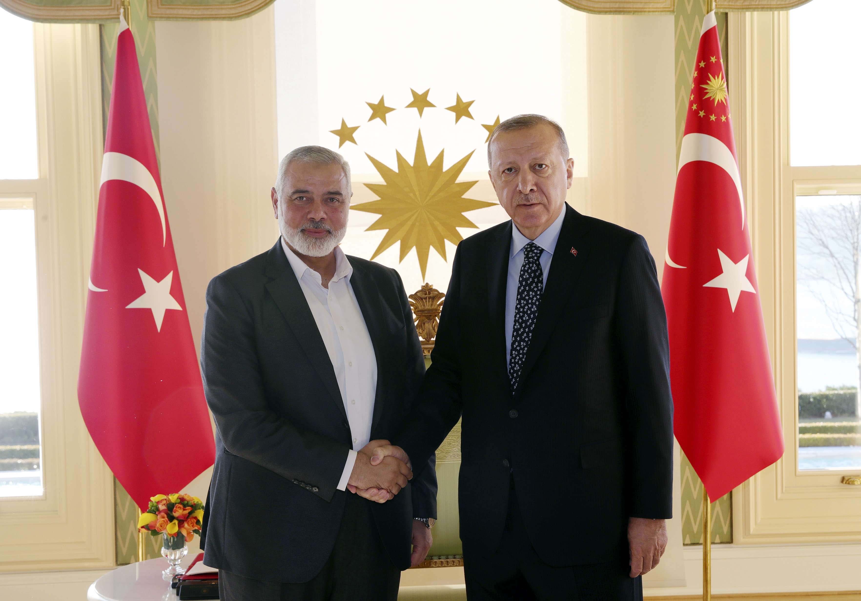 urkey's President Recep Tayyip Erdogan, right, shakes hands with Hamas movement chief Ismail Haniyeh
