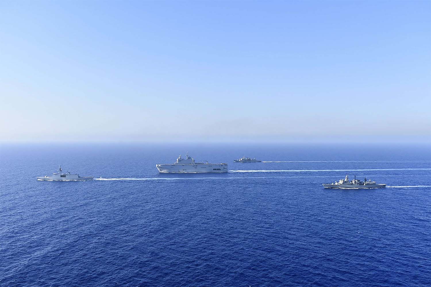 French Tonnerre helicopter carrier, center, and French Lafayette frigate, left, are escorted by Greek and French military vessels 
