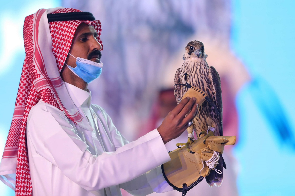 سعودي يحمل الصقر الذي تم بيعه بـ170 ألف دولار