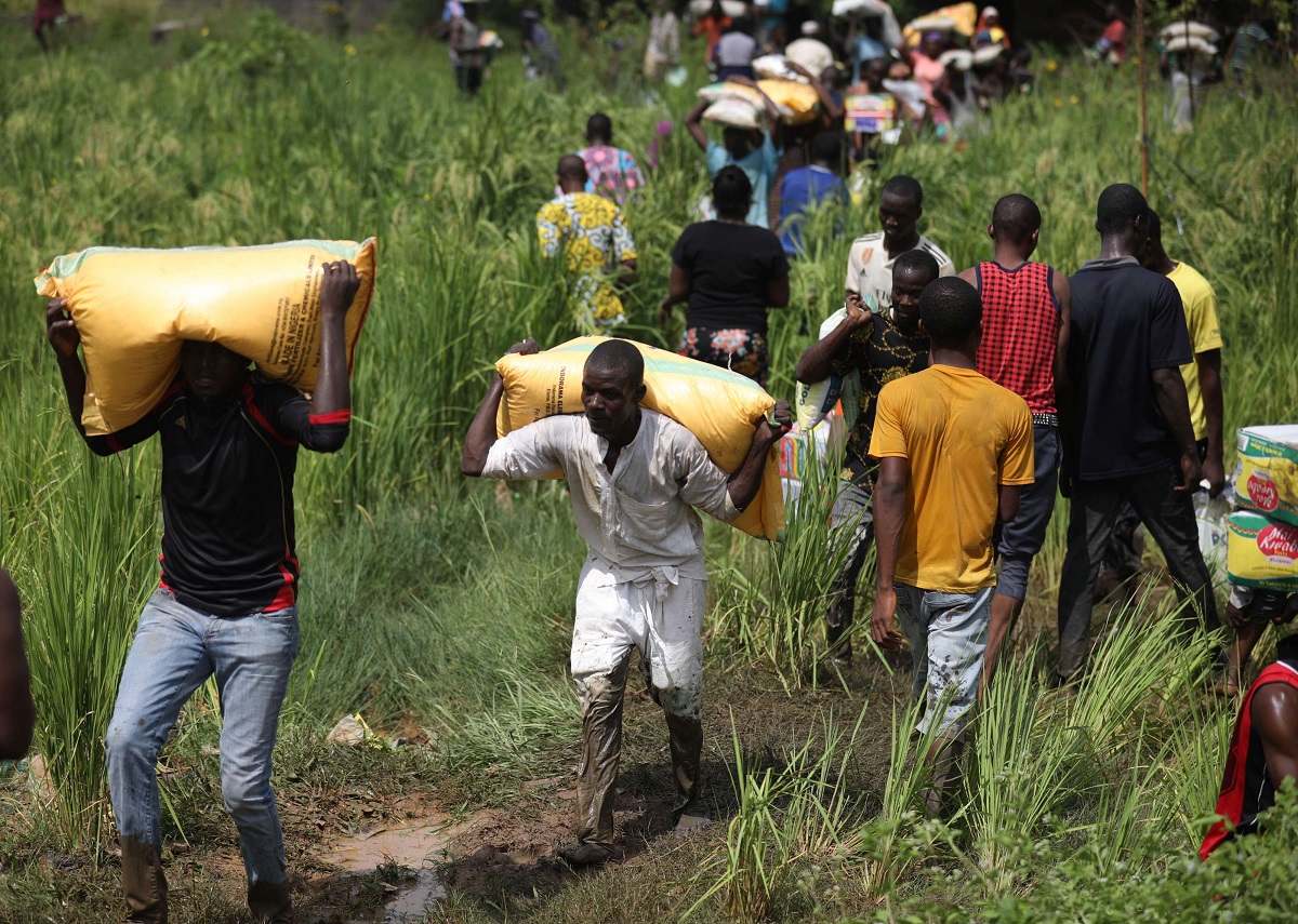 أشخاص يحملون أكياسًا من الطعام أثناء نهب جماعي لمخزن في أبوجا بنيجيريا