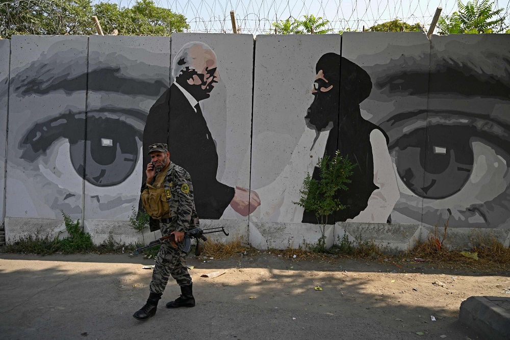 لوحة جدارية ترسم مصافحة بين خليل زاد (يسار) والملا عبد الغني بارادار