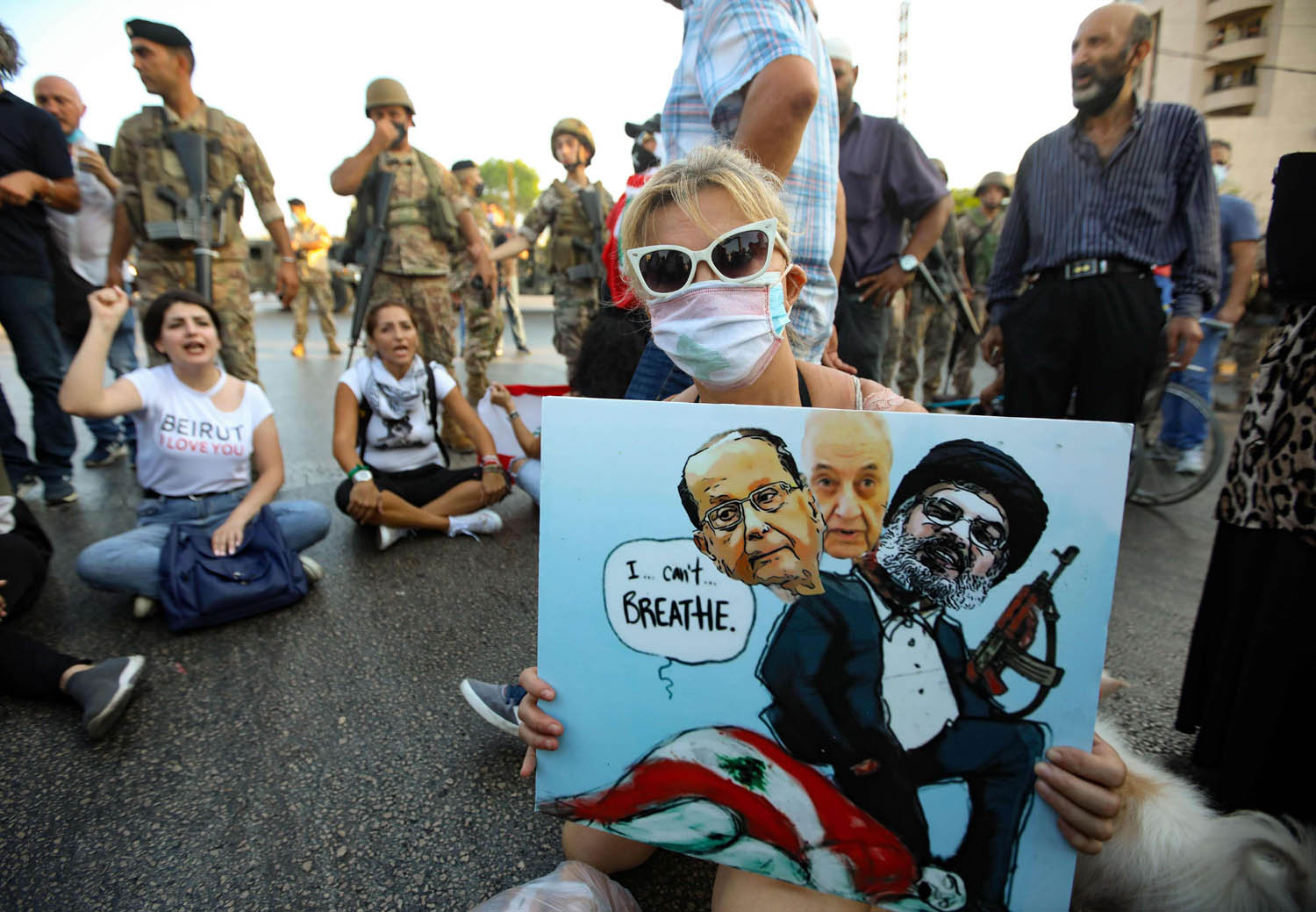 متظاهرون لبنانيون في بيروت يرفعون صورا تندد بالثنائي الشيعي والرئيس عون