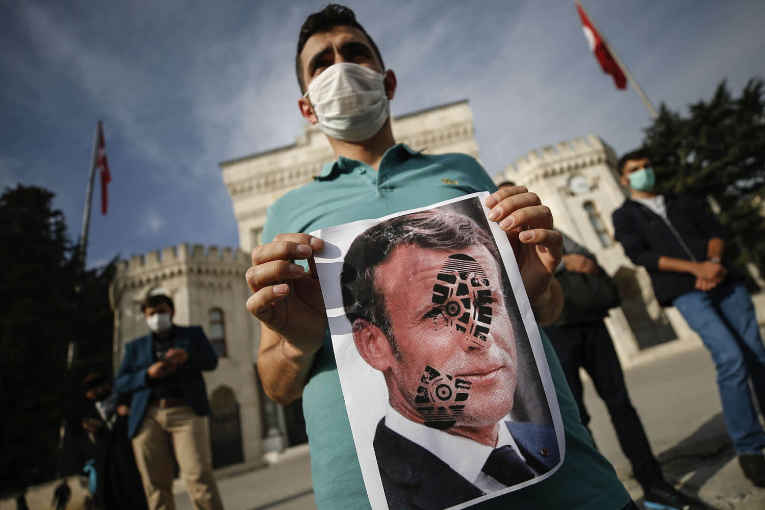 تركي يرفع صورة مشوهة للرئيس الفرنسي ايمانويل ماكرون في اسطنبول