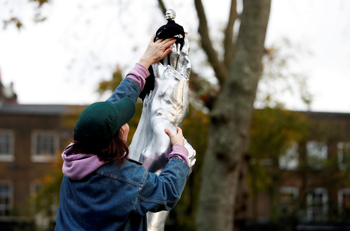 امرأة تحاول تغطية التمثال العاري للكاتبة النسوية ماري وولستونكرافت 