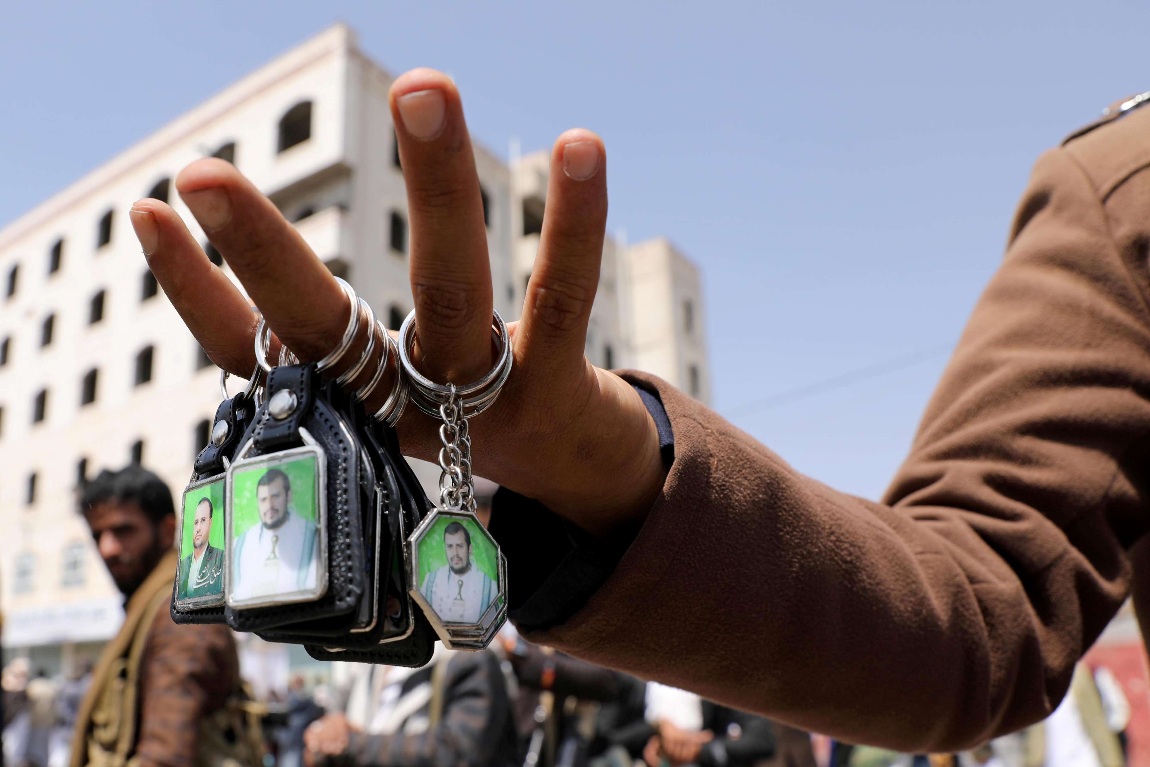 عنصر من ميليشيا الحوثي يحمل صور زعيم الميليشيا عبدالملك الحوثي